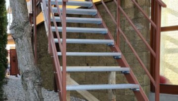 schody so schodnicami z protišmykových roštov s hnedým zábradlím